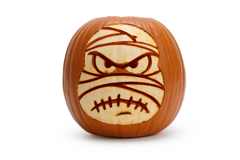 Carved pumpkin with mummy face design on white background