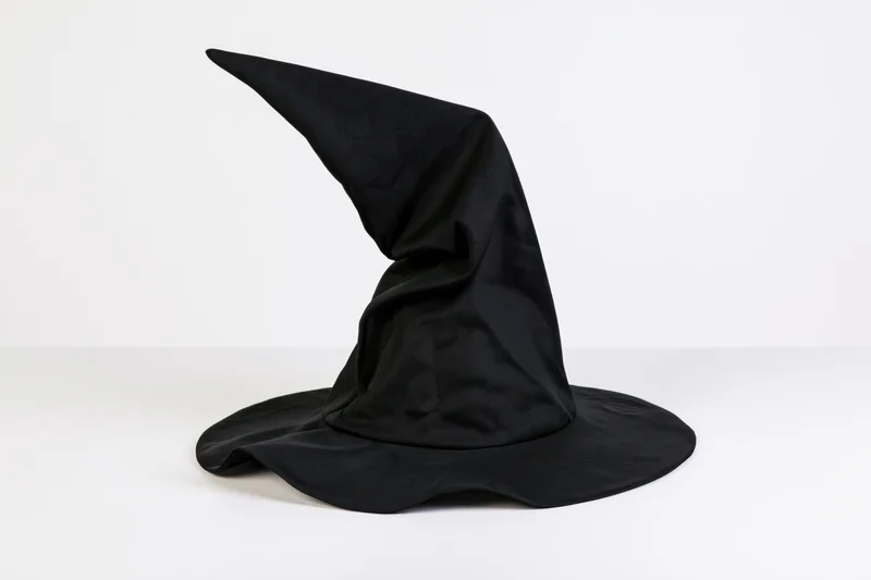 Black fabric witch hat with tall crooked pointed crown on white background