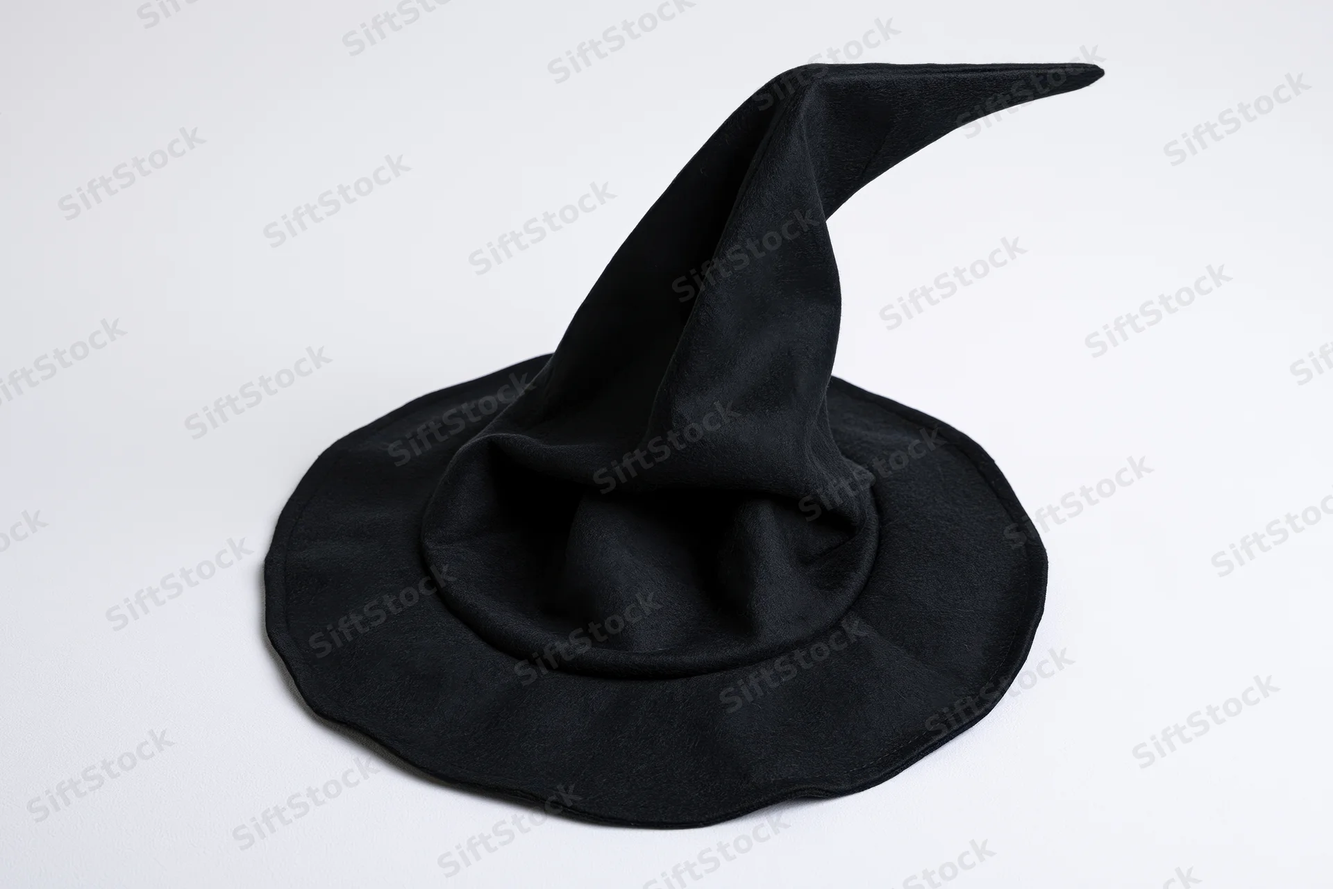 Black witch hat with tall pointed crown and wide brim on white background