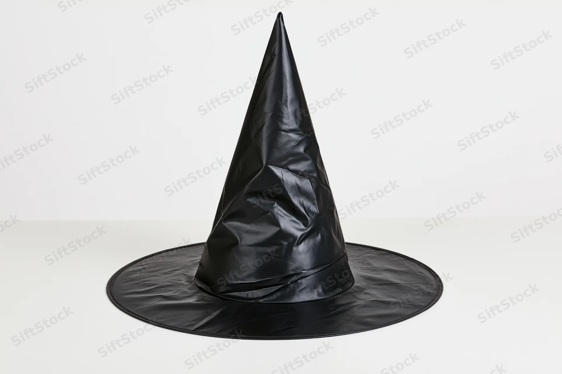 Black plastic witch hat standing upright on white surface