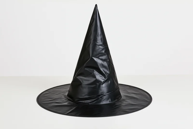 Black plastic witch hat standing upright on white surface