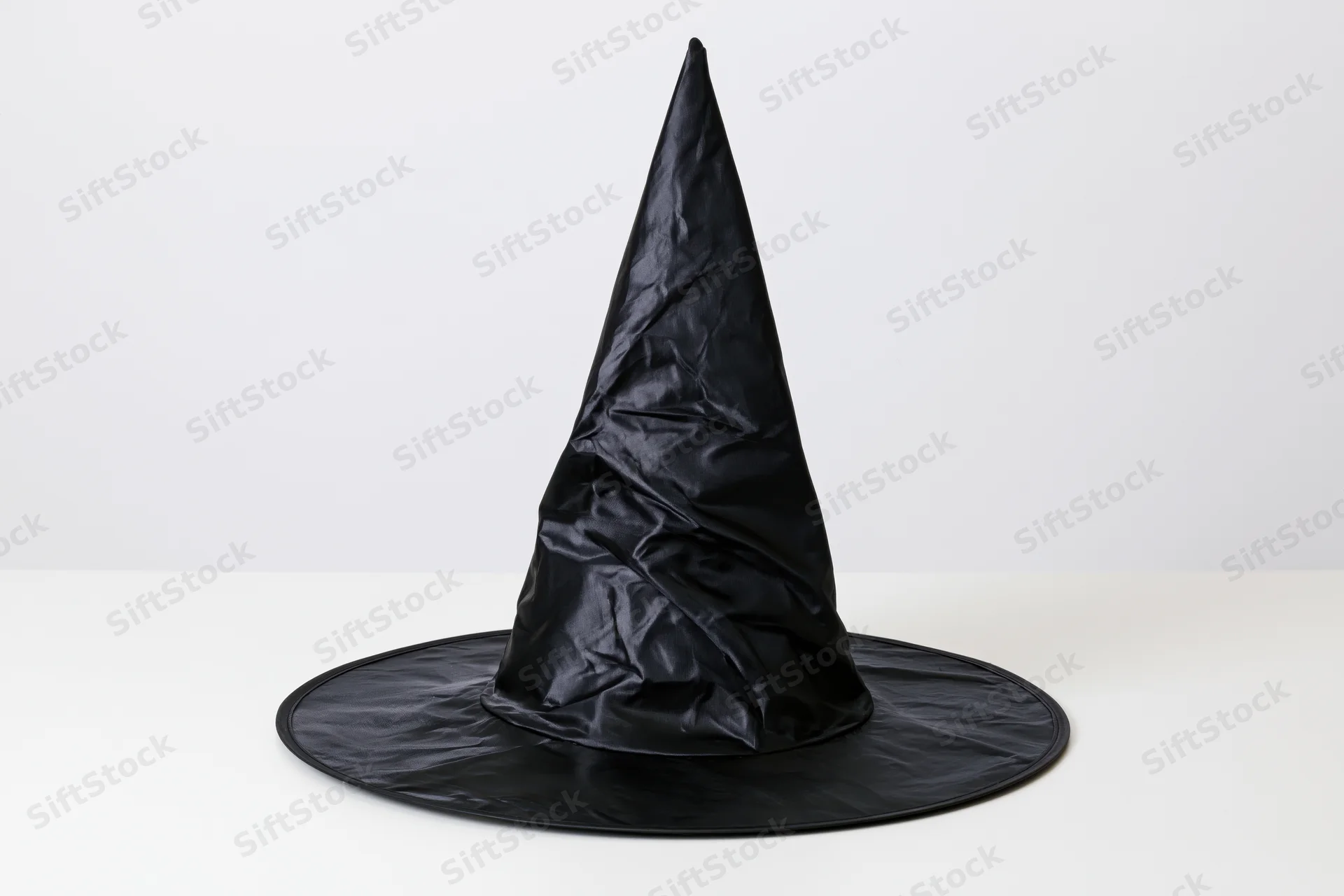 Black plastic witch hat standing upright on white surface