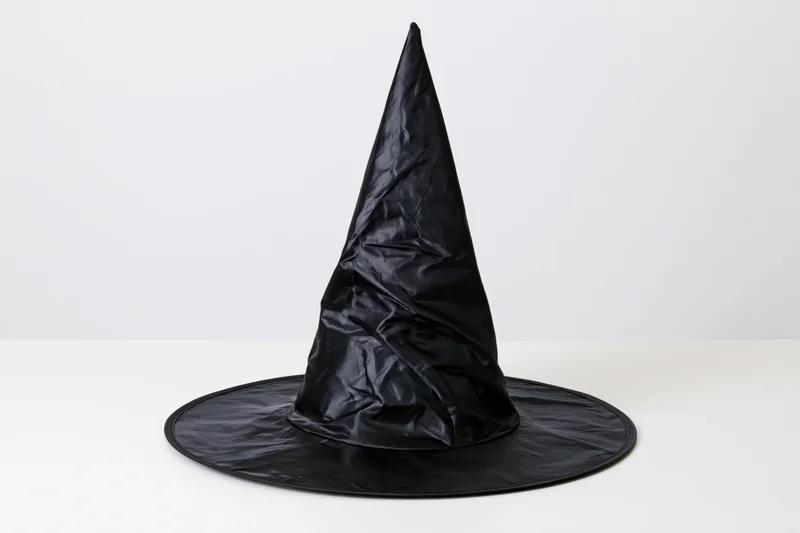 Black plastic witch hat standing upright on white surface