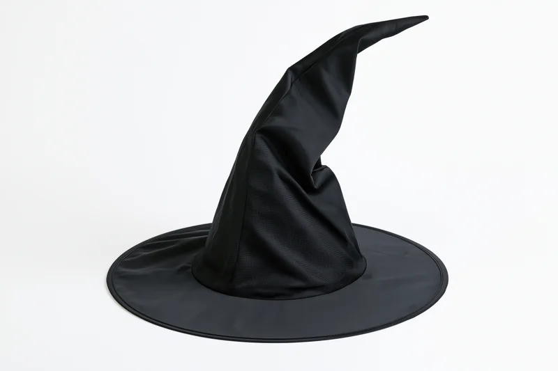 Black pointed witch hat with crumpled fabric on white background