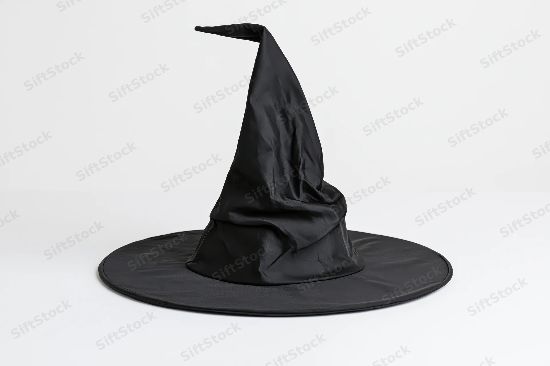 Black pointed witch hat with crumpled fabric on white background