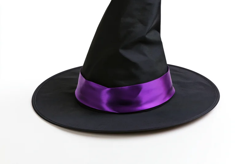 Black pointed witch hat with purple satin band on white background