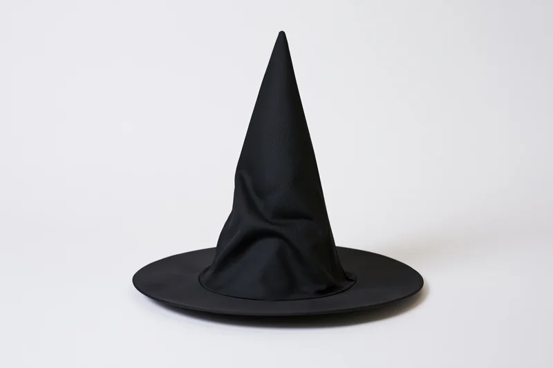 Black witch hat with tall pointed cone and wide flat brim on white background