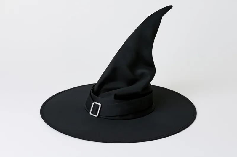 Black witch hat with tall pointed crown and wide brim on white background