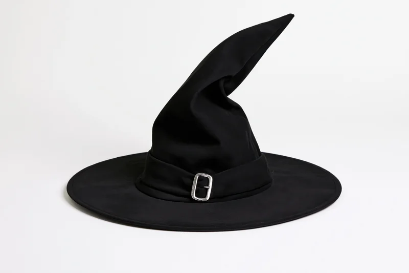 Black witch hat with tall pointed crown and wide brim on white background