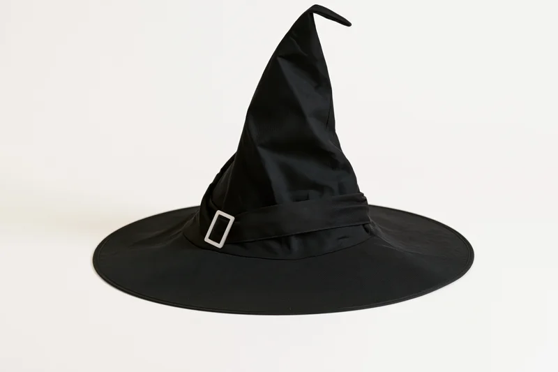 Black witch hat with tall pointed crown and wide brim on white background