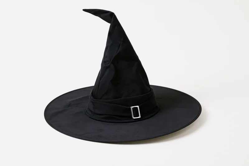 Black witch hat with tall pointed crown and wide brim on white background