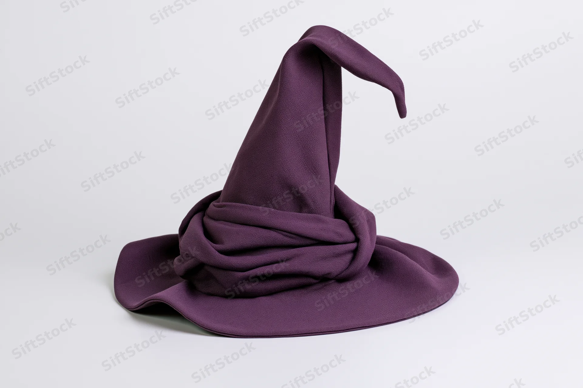 Deep purple fabric witch hat with tall curling tip isolated on white background