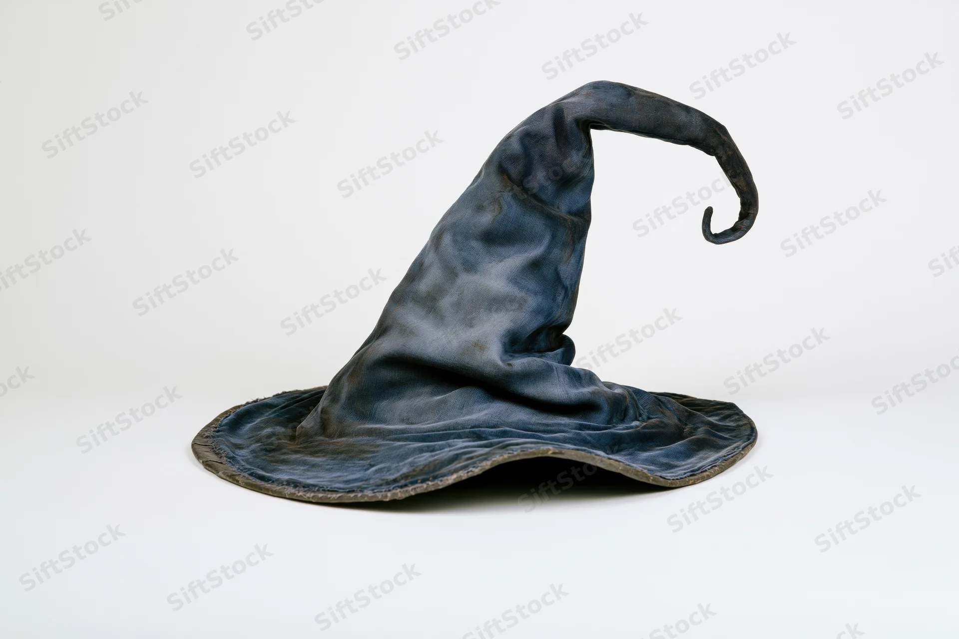 Worn fabric wizard hat with tall curling pointed tip on white background