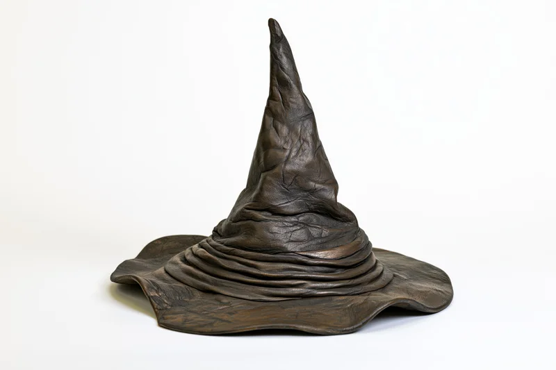 Aged leather wizard hat with tall pointed crown and wide brim on white background