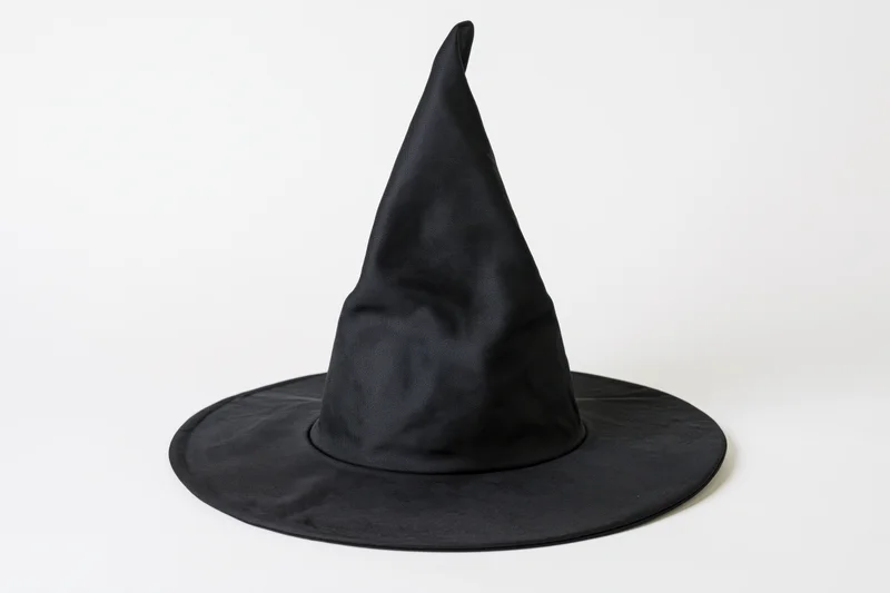 Black fabric witch hat with tall pointed crown and wide brim on white background