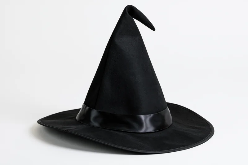 Black witch hat with tall pointed crown and wide brim on white background