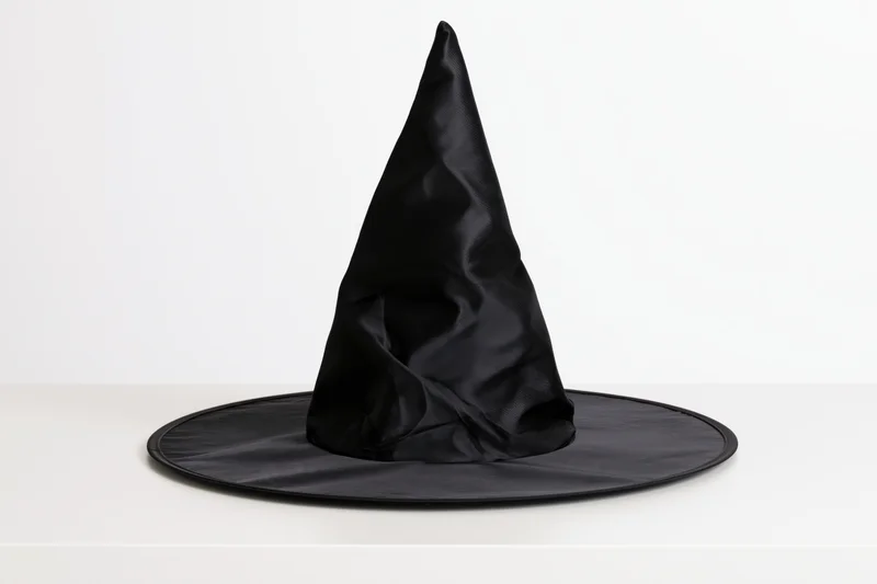 Black plastic witch hat standing upright on a white surface