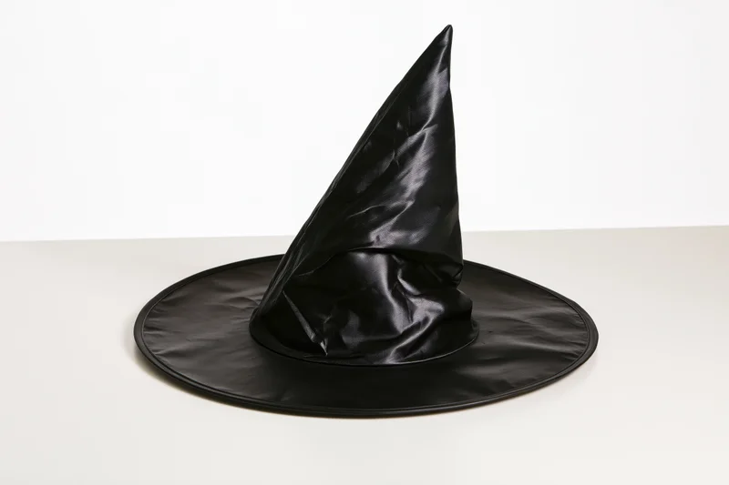 Black plastic witch hat standing upright on a white surface