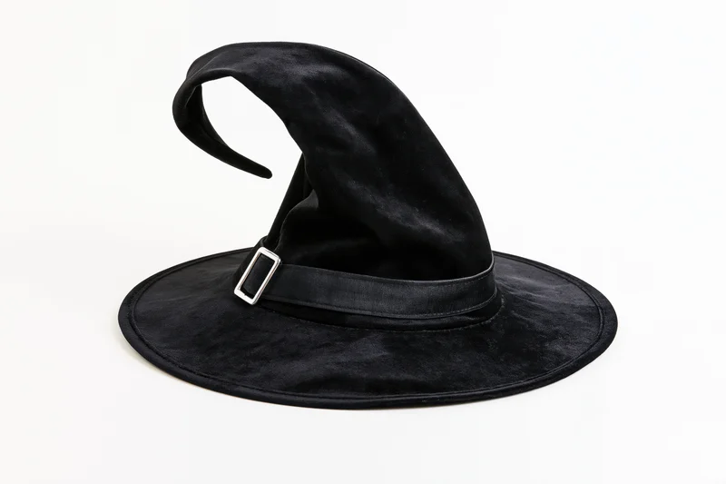Black velvet witch hat with curved pointed tip on white background