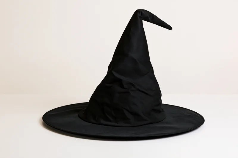 Black witch hat with tall pointed crown and wide flat brim on white background