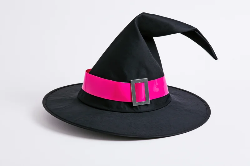 Black witch hat with pink ribbon and buckle on white background