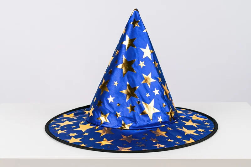 Blue wizard hat with gold foil stars sitting upright on white surface