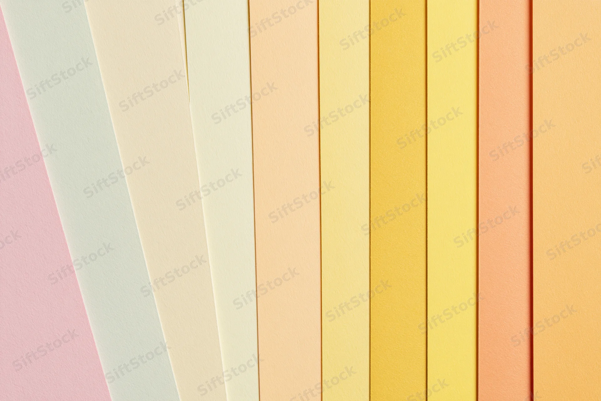 Fanned sheets of pastel colored paper arranged in a flat lay display