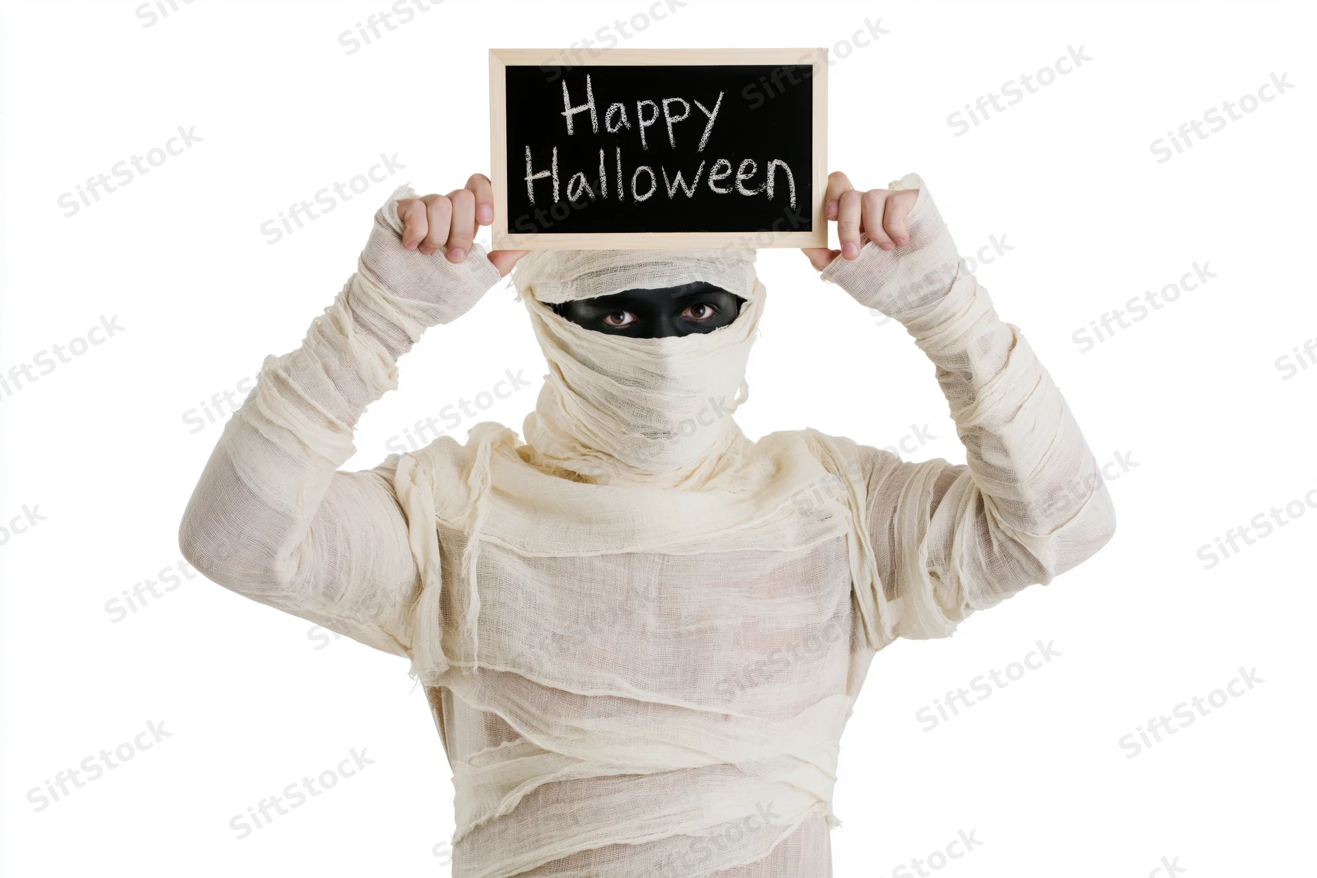 Person in mummy costume holding chalkboard sign with happy halloween message isolated on white background