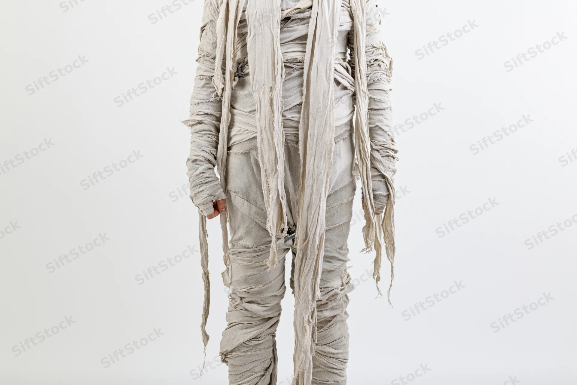 Person in full-body mummy costume wrapped in bandages standing upright against white background