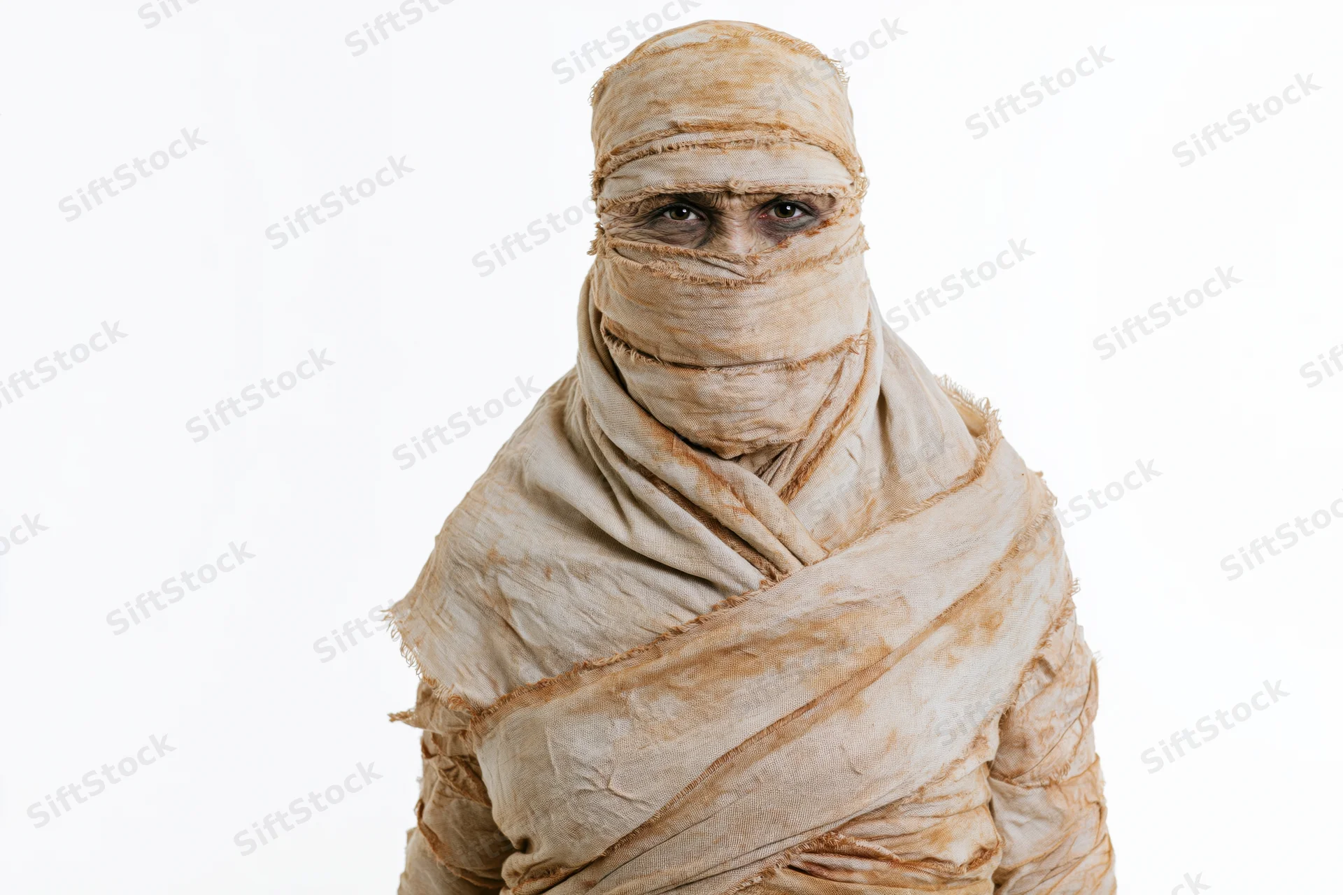 Person in full mummy costume wrapped in bandages standing upright against white background
