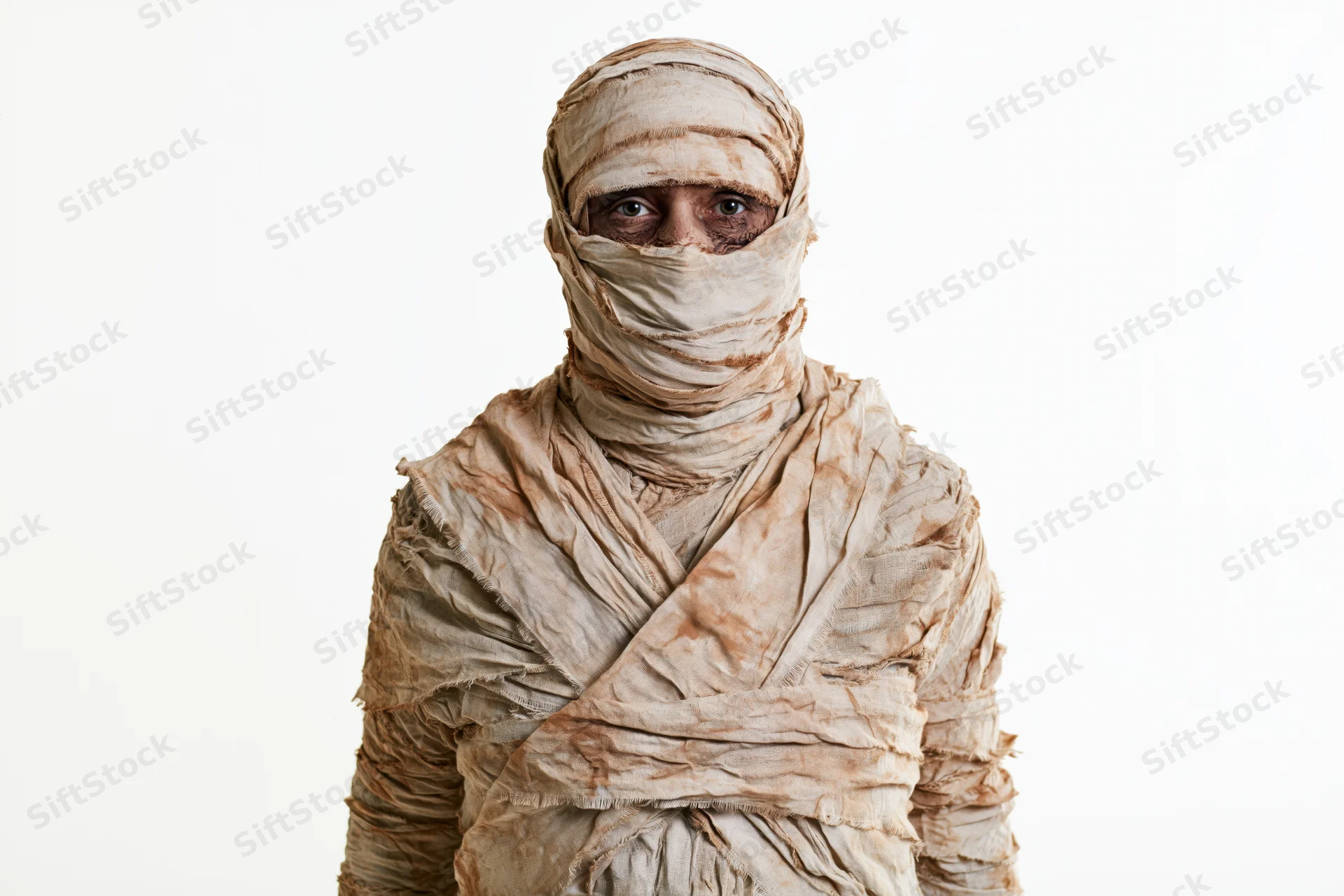 Person in full mummy costume wrapped in bandages standing upright against white background