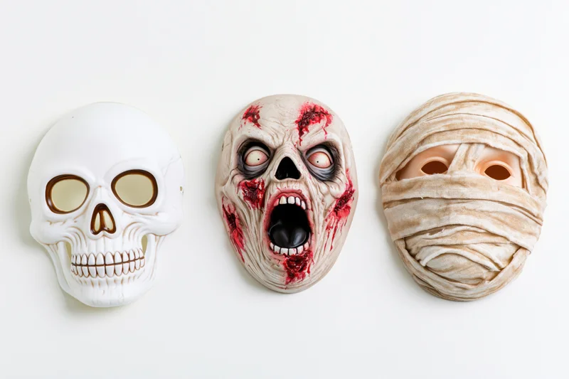 Three halloween rubber masks — skull, zombie, and mummy — arranged side by side on a white background