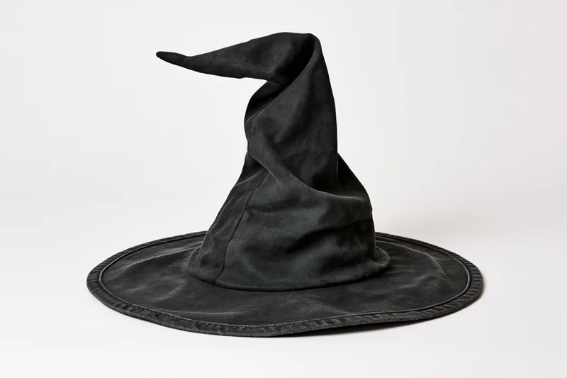 Black witch hat with crooked twisted tip on white background