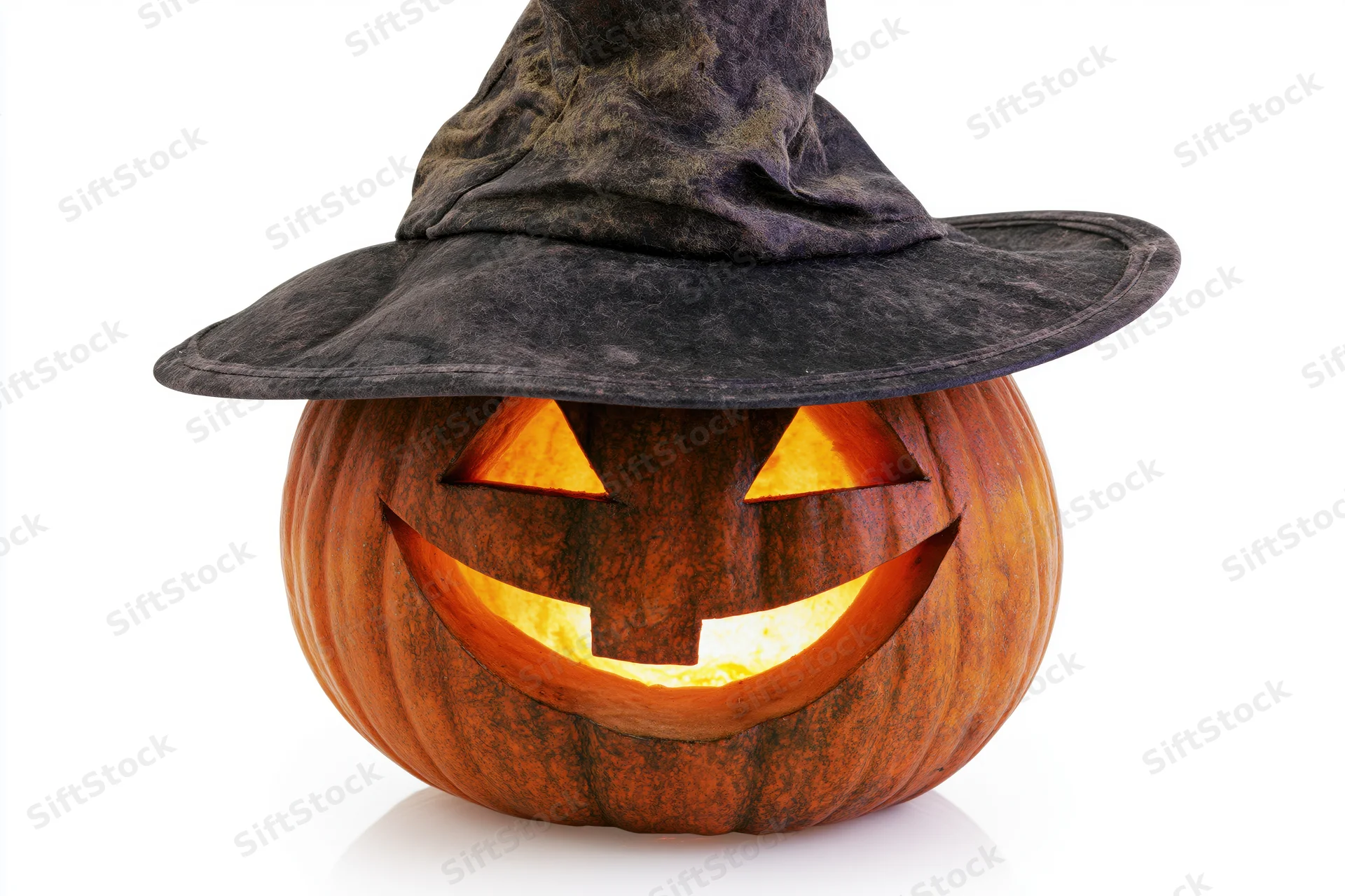 Carved jack-o-lantern with glowing face wearing a dark witch hat on white background