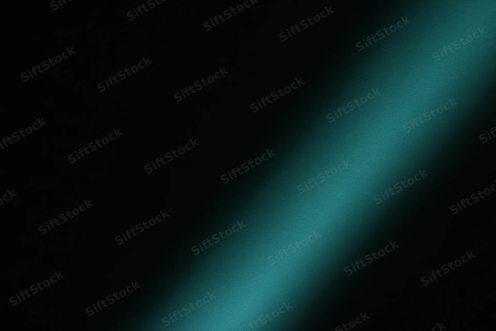 Diagonal band of soft teal-green light across dark background