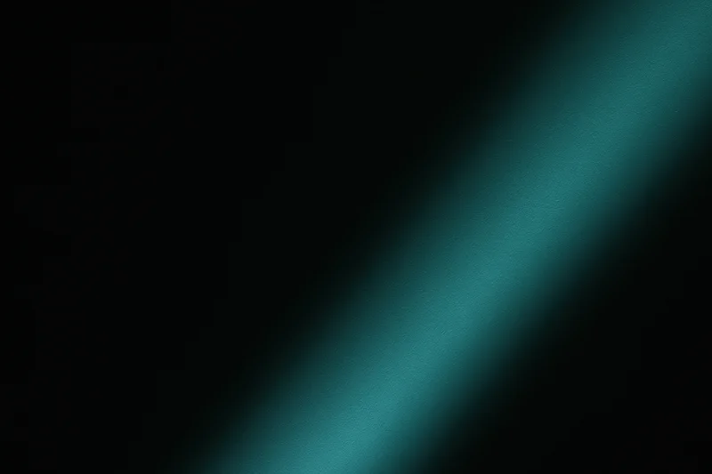 Diagonal band of soft teal-green light across dark background