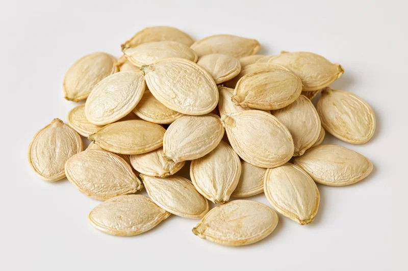 Pile of dried pumpkin seeds on white background