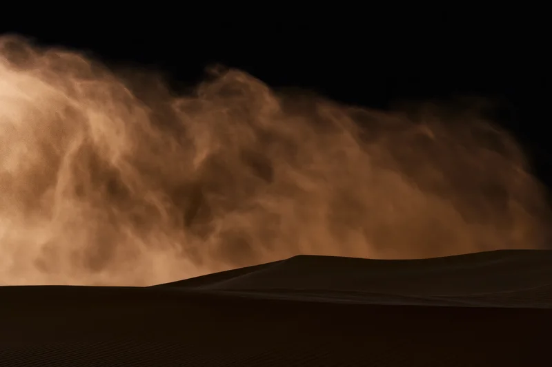 Massive sandstorm haboob rolling across desert dunes at night