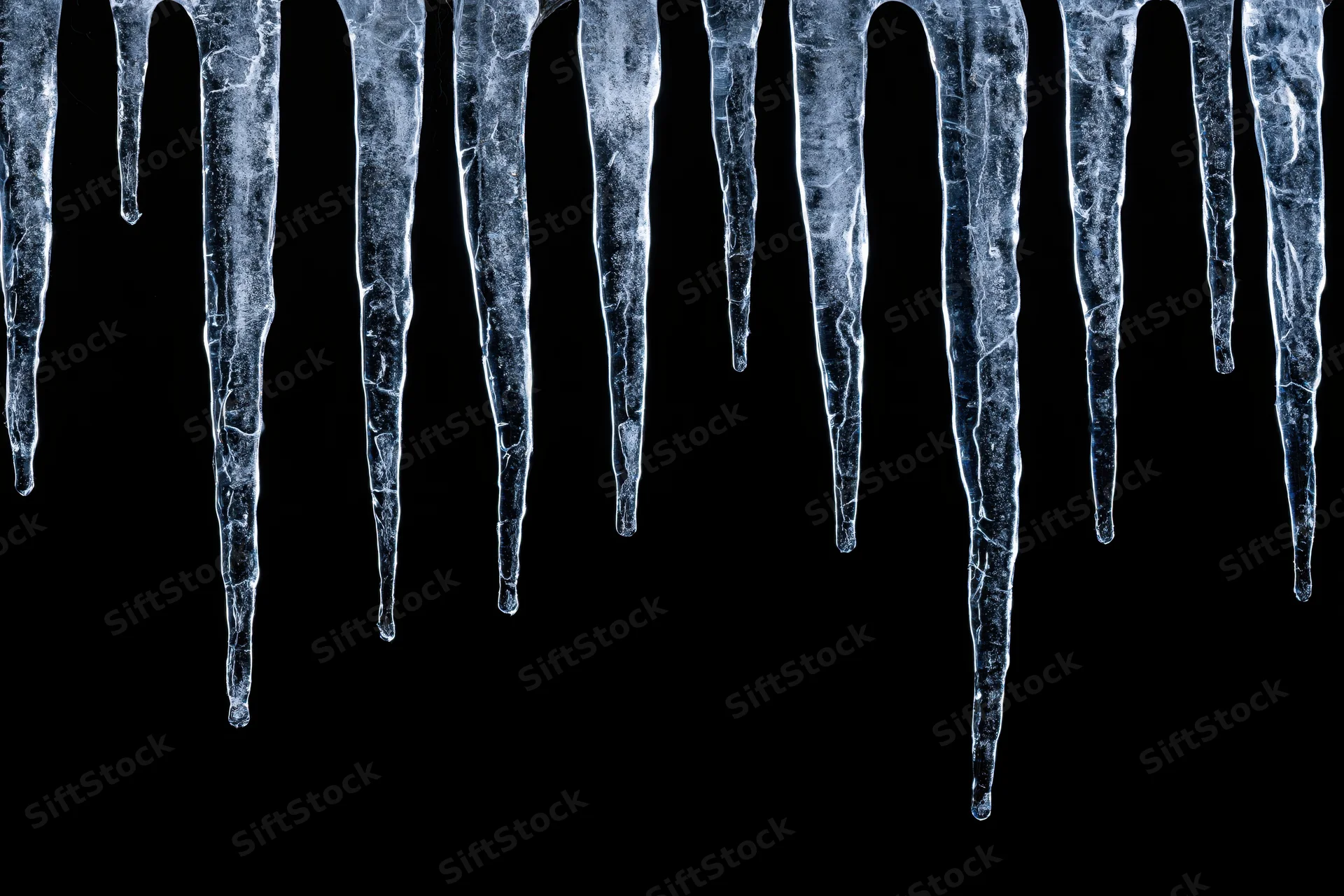 Row of natural icicles hanging down against black background