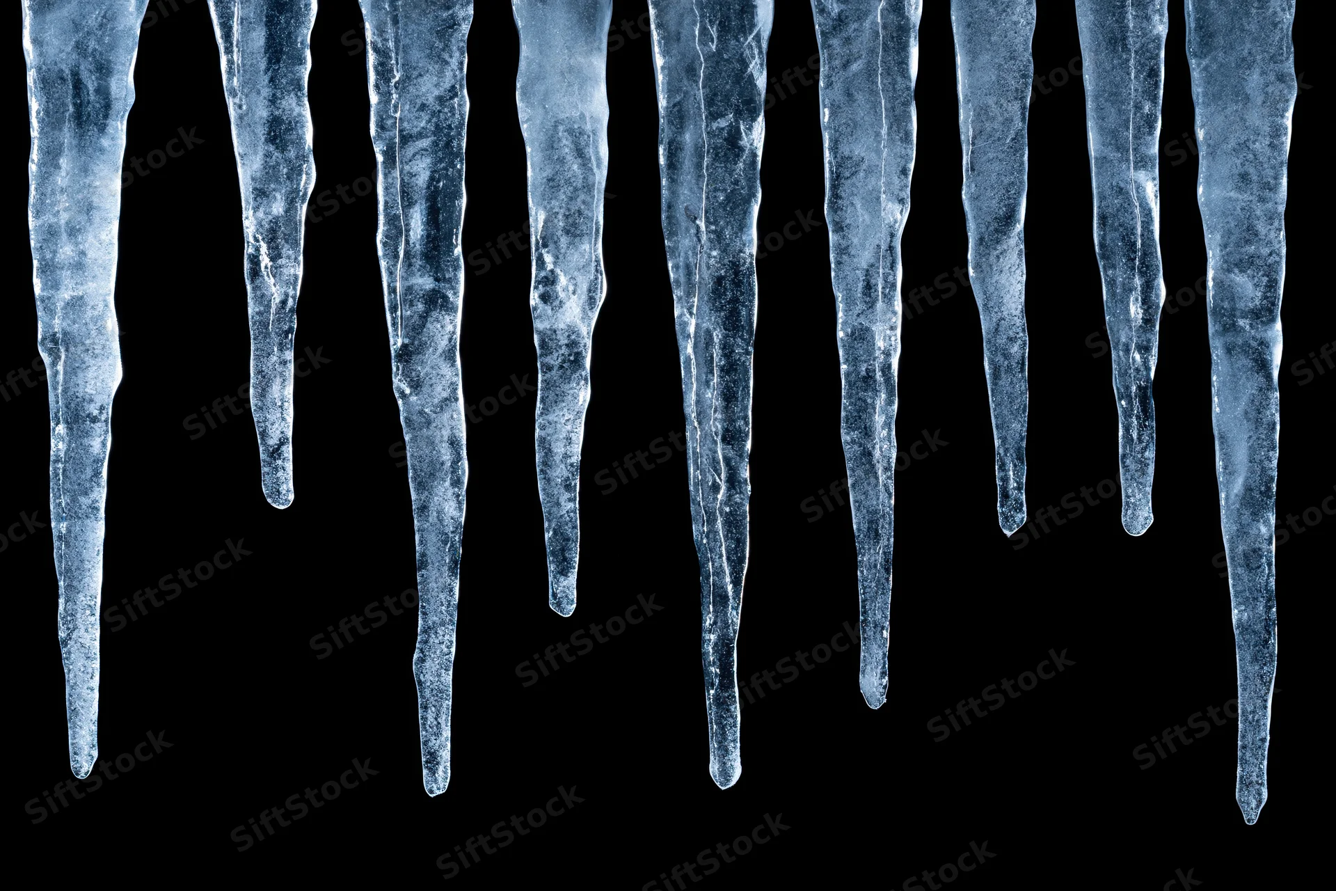Row of natural icicles hanging vertically against black background