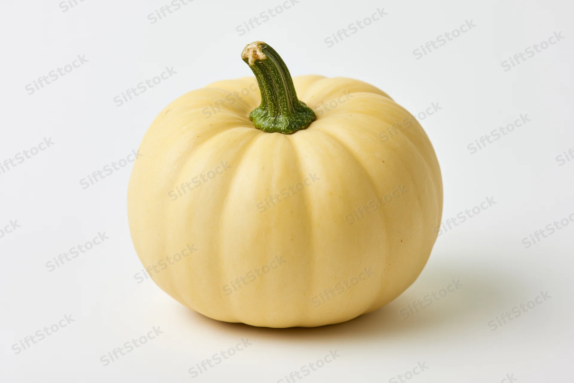Pale yellow pumpkin with short green stem on white background