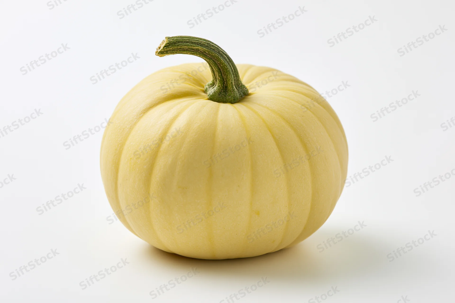 Pale yellow pumpkin with short green stem on white background