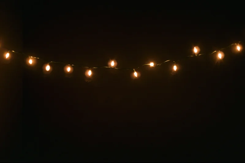String of warm white fairy lights draped horizontally across dark background