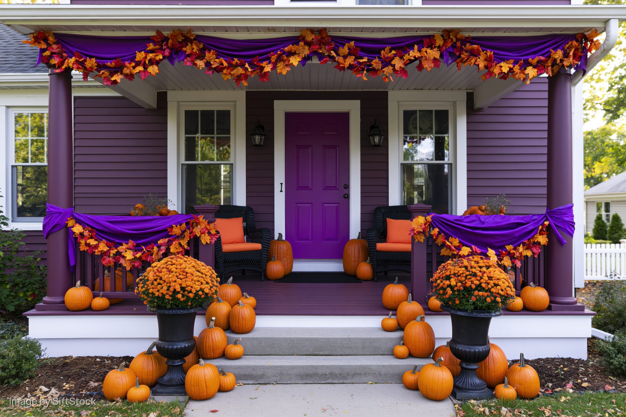 Purple house porch decorated with pumpkins and autumn garlands for halloween