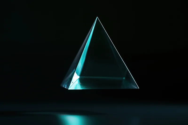 Translucent glass tetrahedron floating against a pure black background