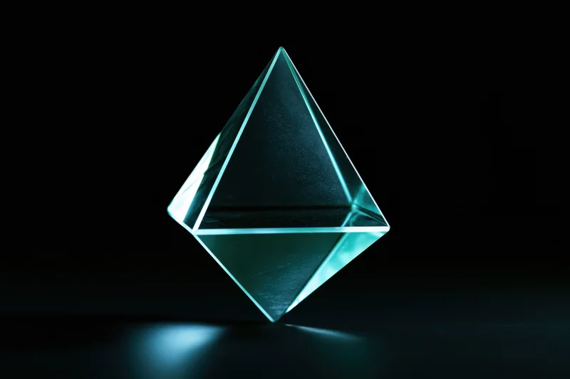 Translucent glass tetrahedron floating against a pure black background