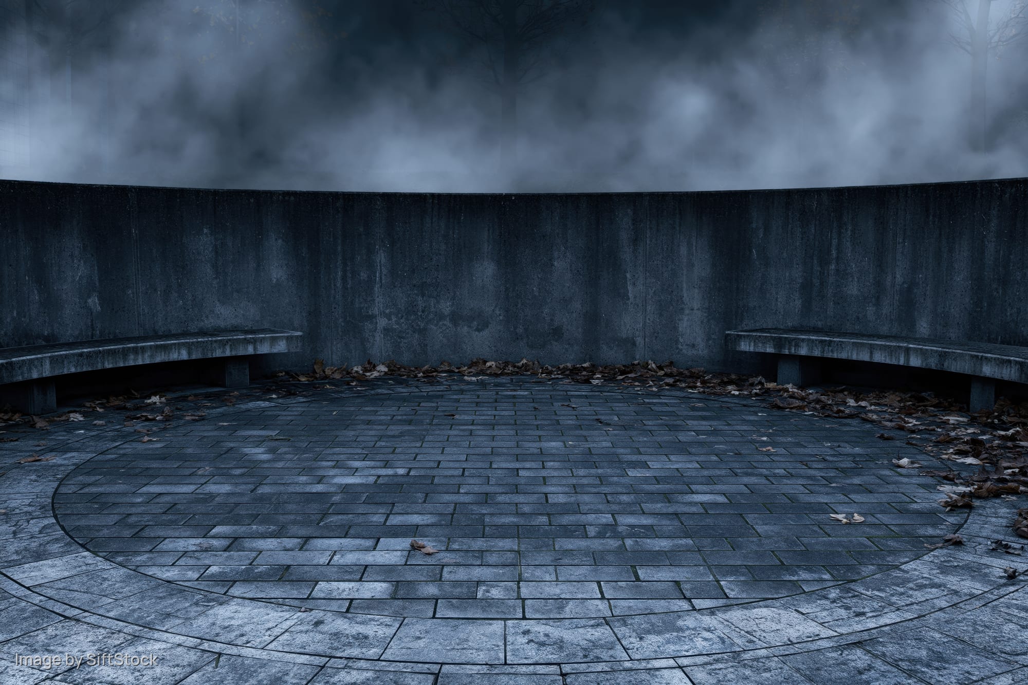 Circular stone courtyard at night with fog and benches, empty and abandoned