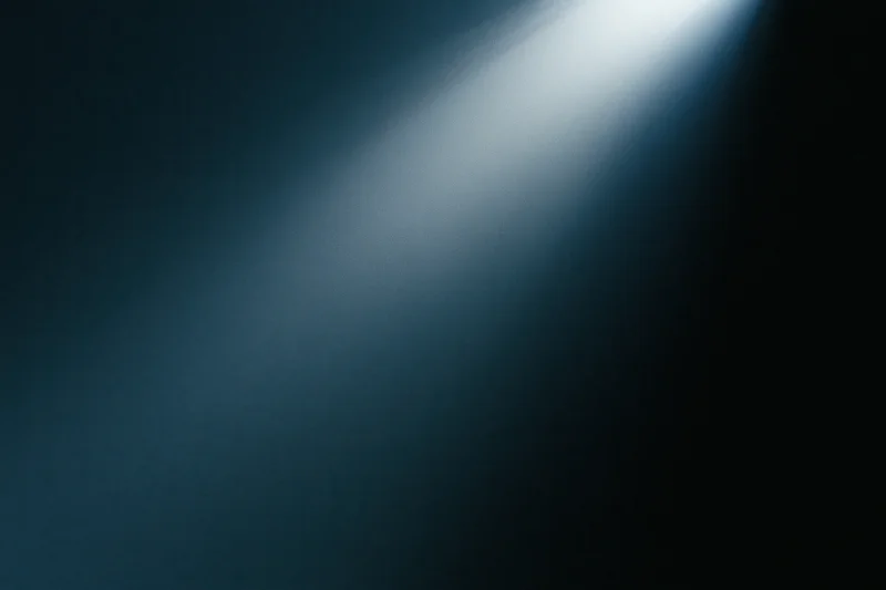 A single beam of cool light cutting through dark space on a stage