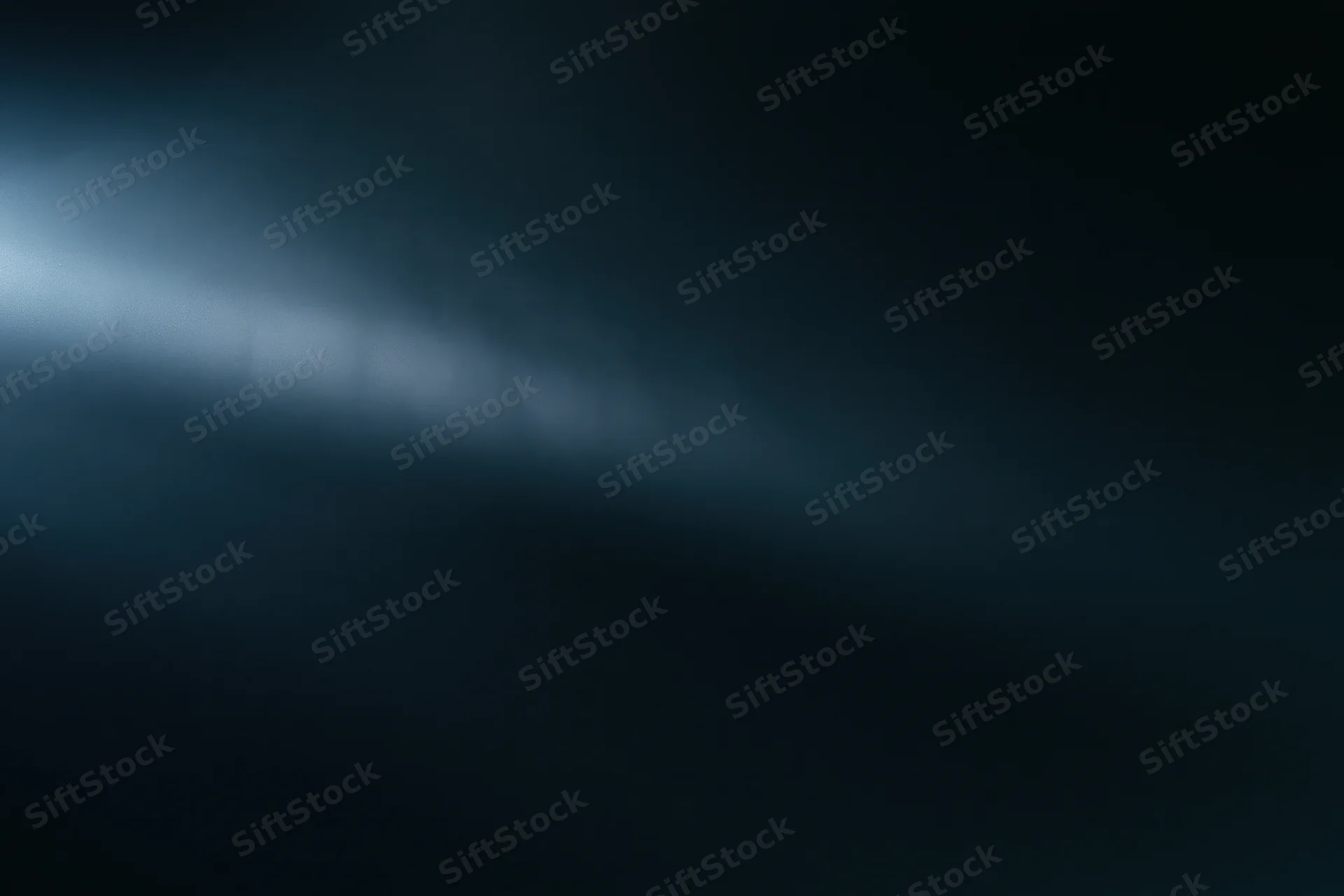 A diffused beam of cool blue light cutting through a dark atmospheric background