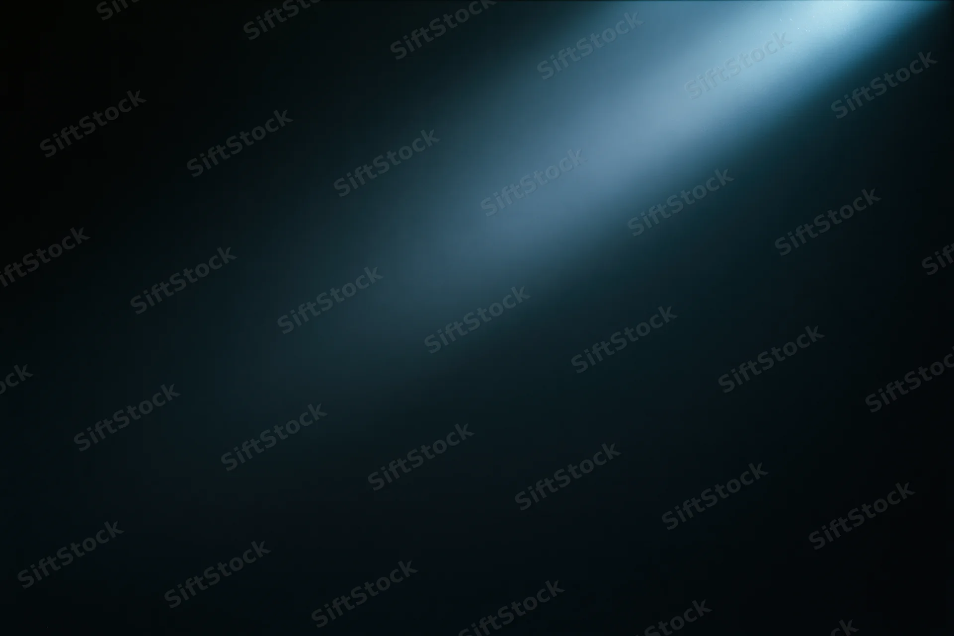 A single diffused beam of cool blue light on a dark abstract background with copyspace